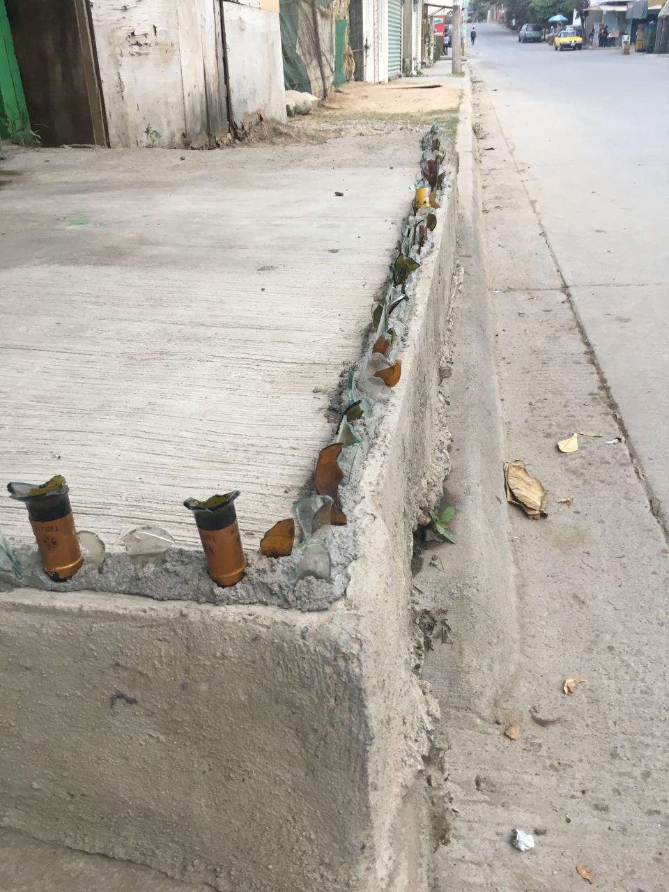 12y13Bahía (5) Vecino “adorna” con filosos vidrios su banqueta; lo obligan a quitarlos