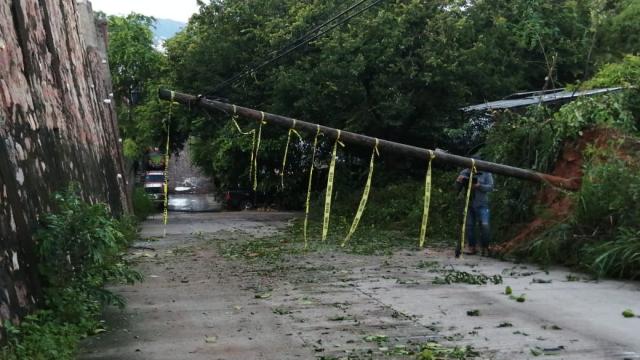 Poste de teléfono cae y queda colgado sobre avenida en Coapinole Poste caído sobre avenida